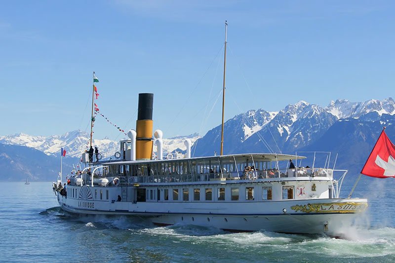 A boat leaving the pear in direction to the moutains.