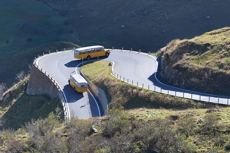 Buses driving in a curvy road in the Swiss Alps