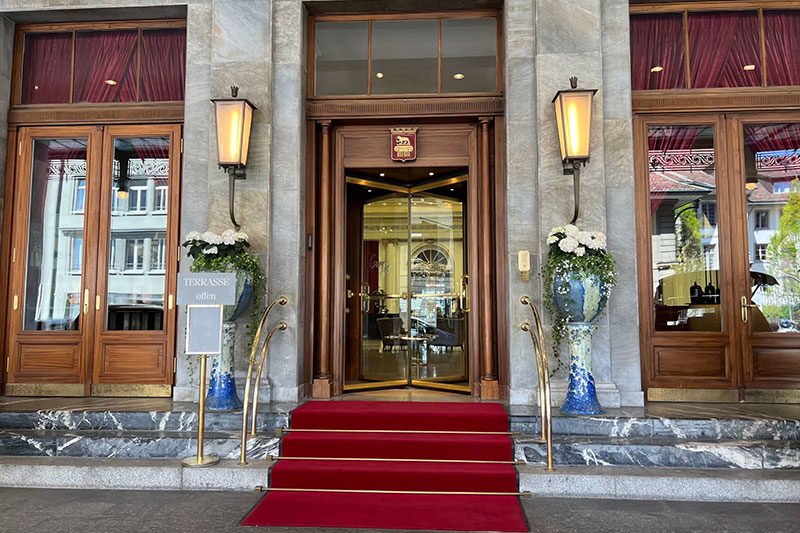 The entrance of a luxury hotel with a red carpet in the stairs
